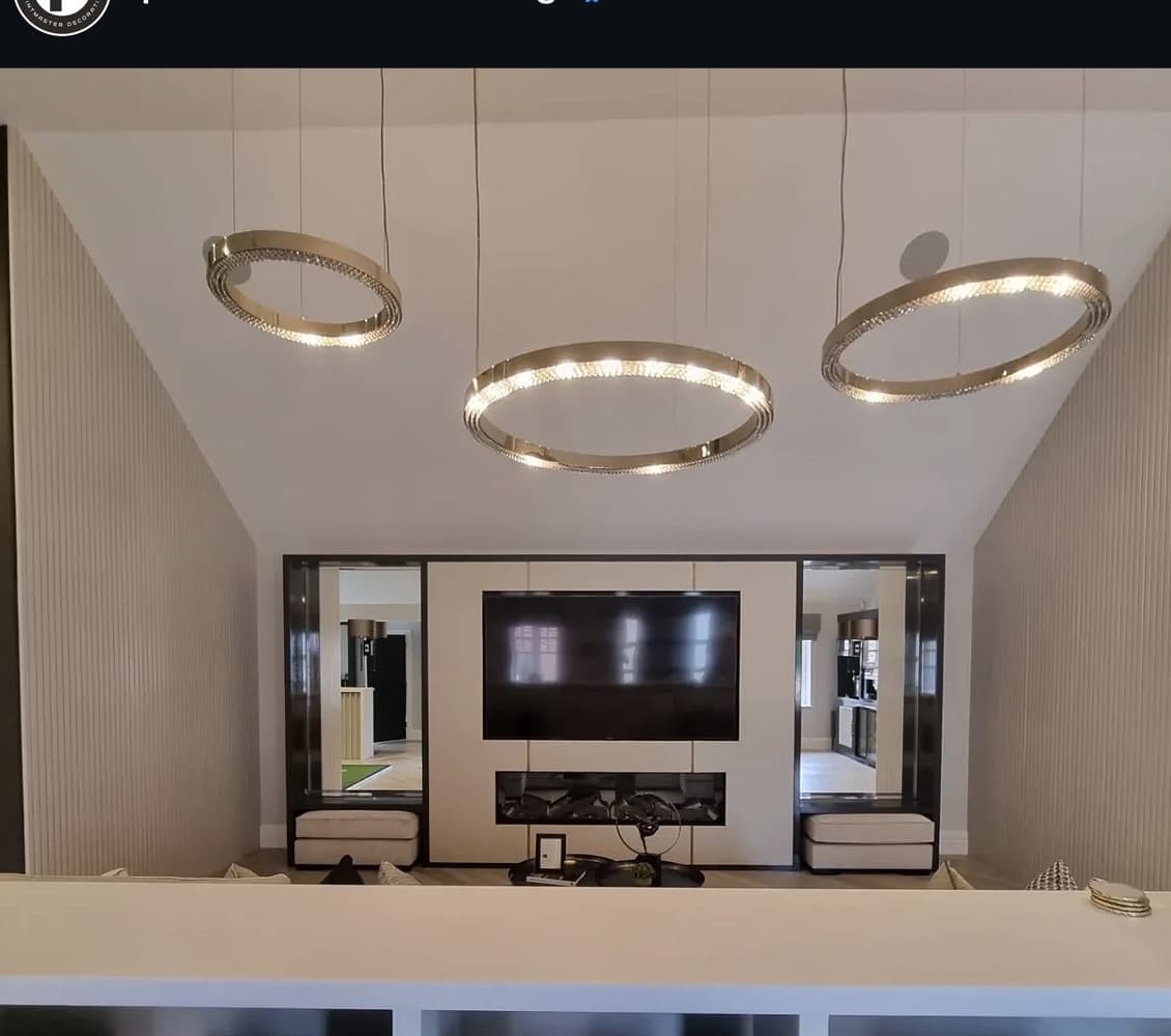 Media wall with fitted units and a fluted panelled surround under a vaulted ceiling