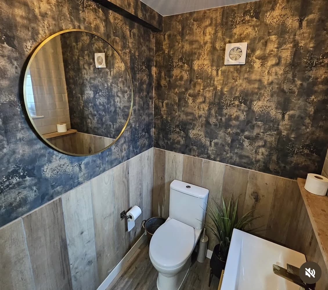 WC with a blue and bronze marbled wallpaper above timber-effect panelling